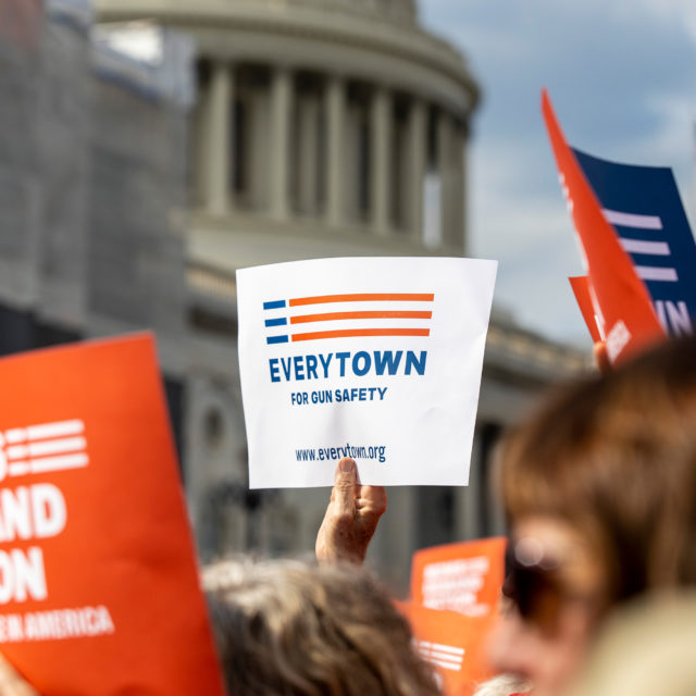 An Everytown sign is raised in a crowd in front of the Capitol