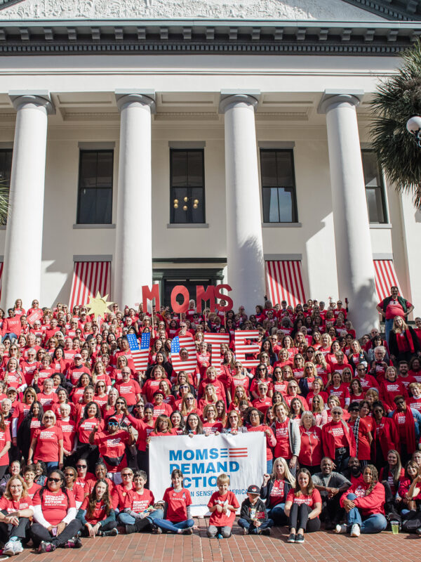 A large group of Moms Demand Action volunteers stand in front of the capitol at an Advocacy Day