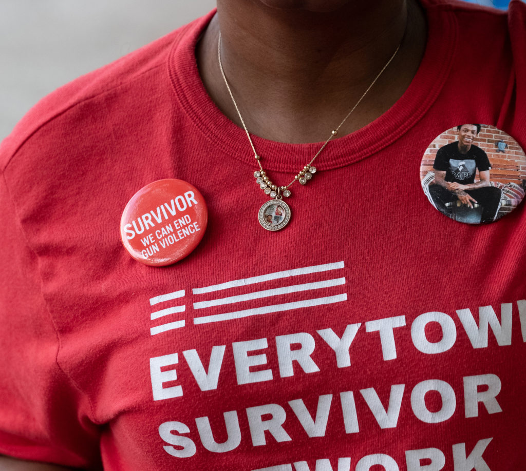 A close up of a woman with a pin of their lost loved one and a survivor network shirt