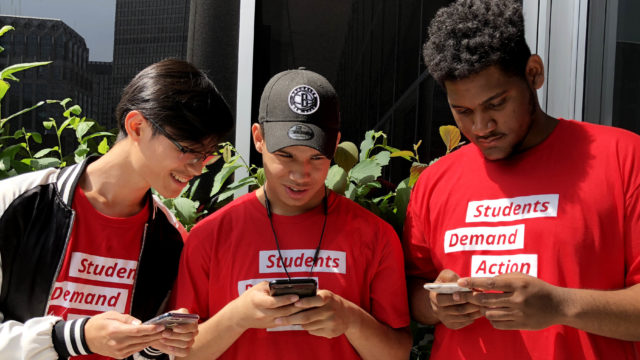 Three Students Demand Action volunteers texting on their phones