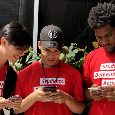 Three Students Demand Action volunteers texting on their phones
