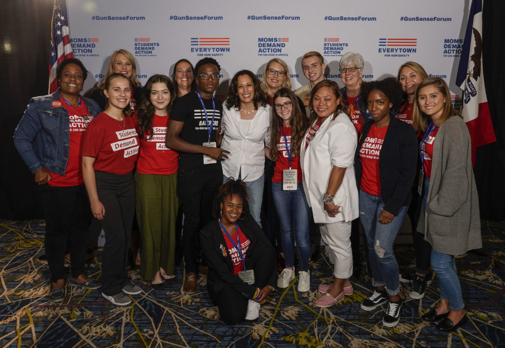Group photo of 14 Moms and Students Demand Action volunteers with Kamala Harris at the Gun Sense Forum in 2019. 