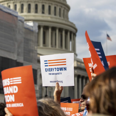 An Everytown sign is raised in a crowd in front of the Capitol