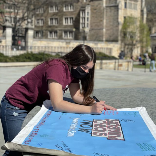 A Students Demand Action volunteer signs the Background Checks Now mural in CT on the Road Trip for Background Checks