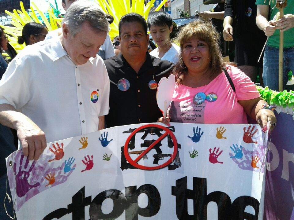 Millie and Rafael Burgos hold up an anti-gun violence sign at a community event