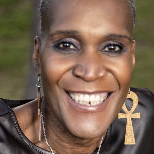 Andrea Jenkins, Minneapolis City Council President, smiles while seated on a bench