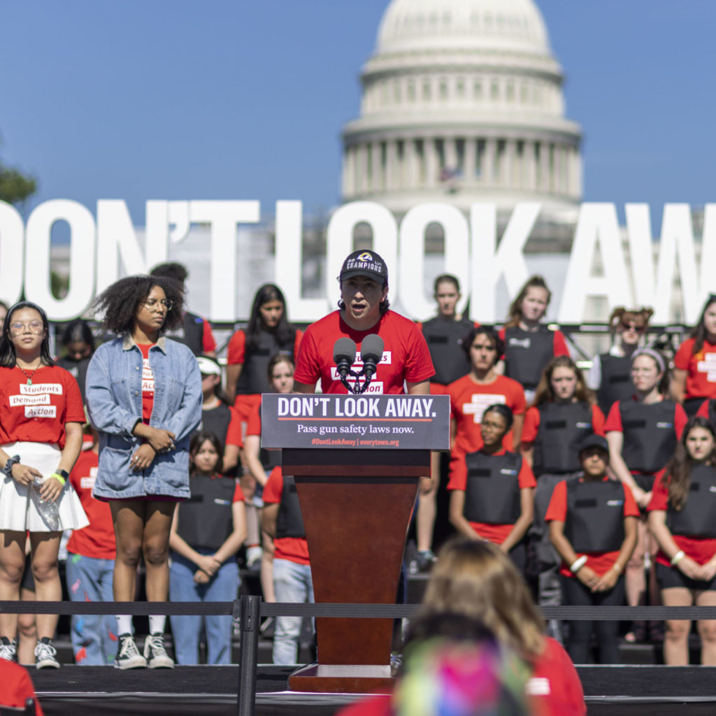 Emmanuel “Manny” Macedo speaking at the podium at the Don't Look Away rally