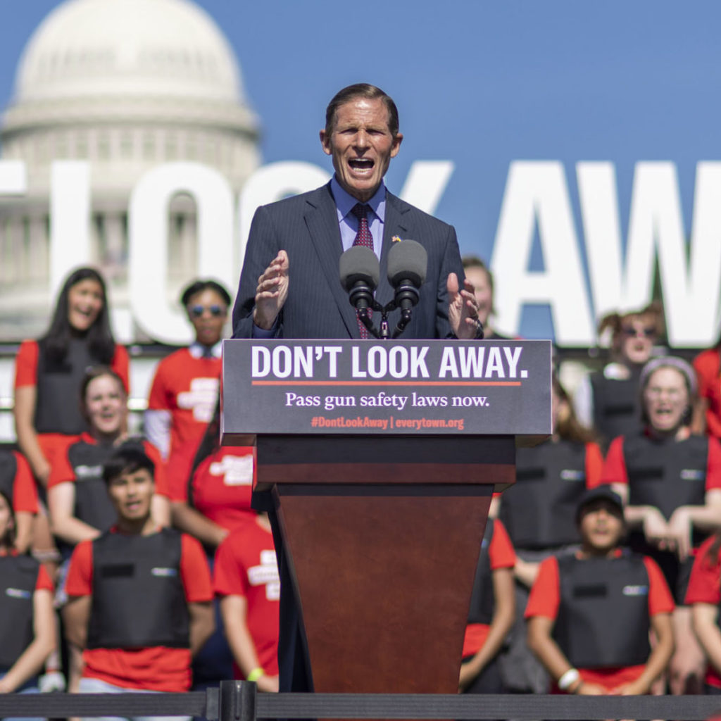 Senator Richard Blumenthal speaking at the podium at the Don't Look Away rally