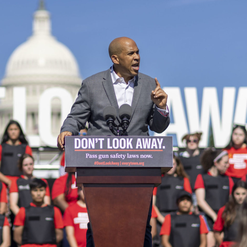 Senator Cory Booker speaking at the podium at the Don't Look Away rally