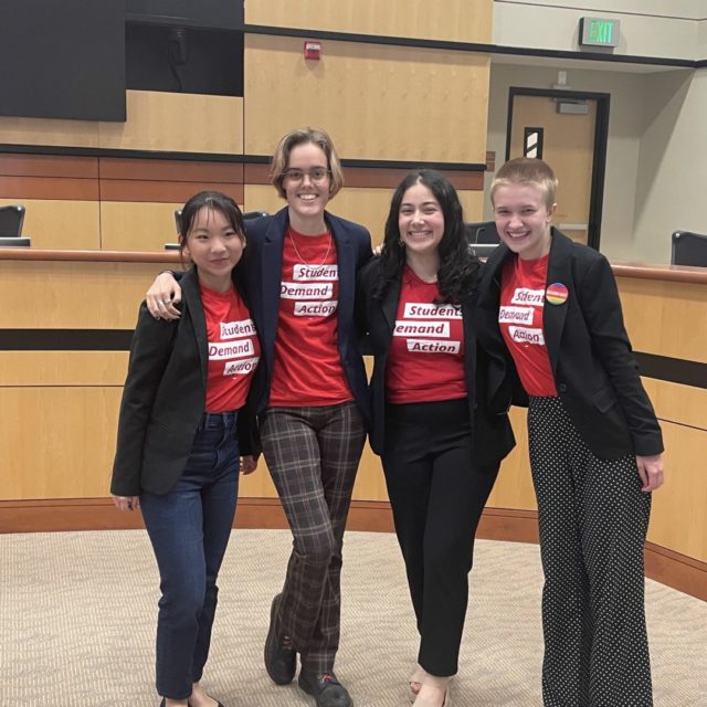 Flynn Williams and three other Students Demand Action volunteers smile for a photo together