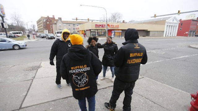 a community violence intervention group walks together on a city sidewalk