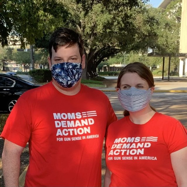 Moms Demand Action volunteer Claire Hein Blanton poses for a photo next to her husband. They are both masked and wearing red Moms Demand Action t-shirts.