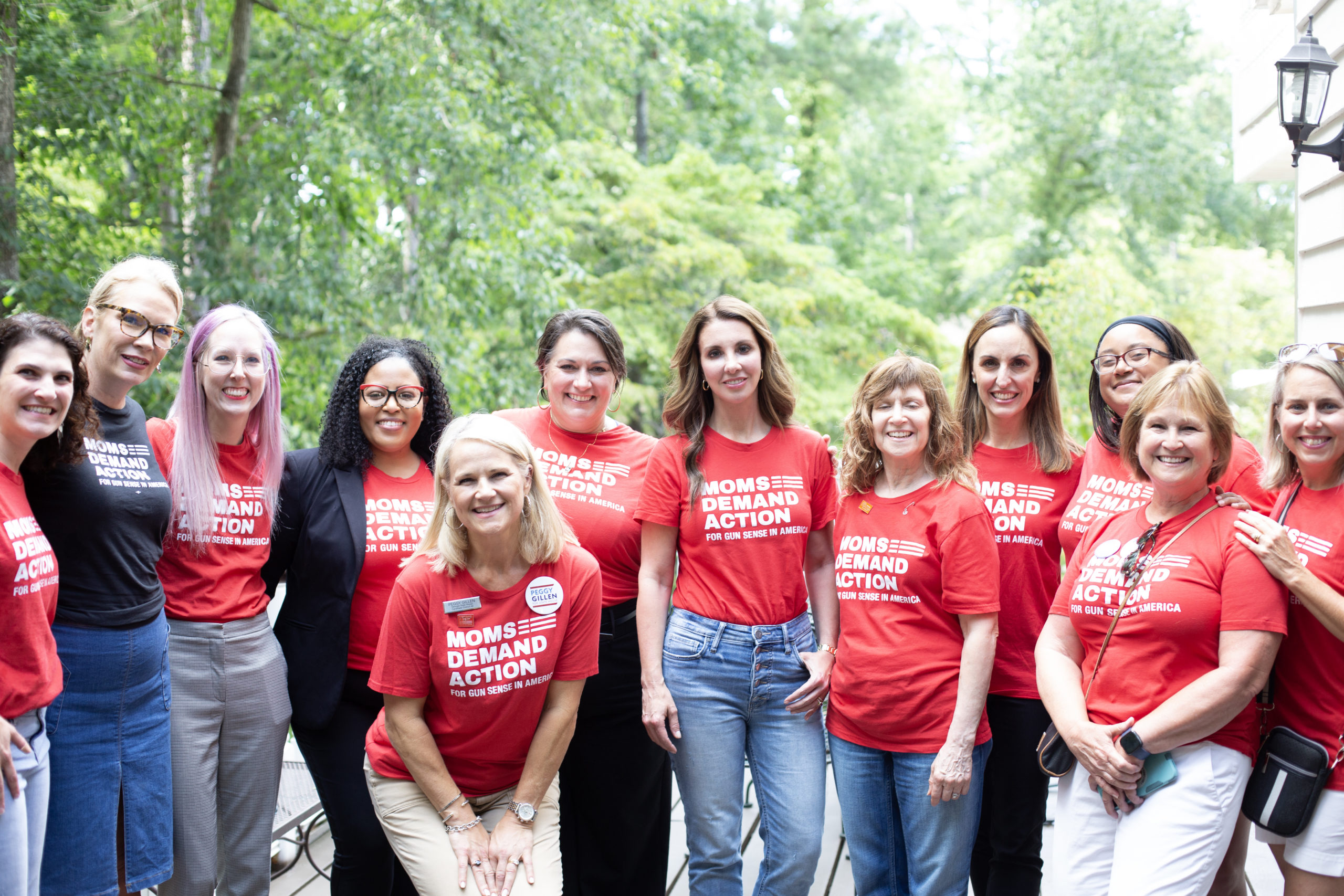 Moms Demand Action volunteers pose in red Moms Demand Action t-shirts alongside founder Shannon Watts