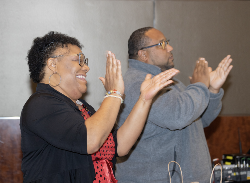 Two people clap at the Community Safety Fund convening