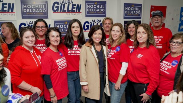 Moms Demand Action volunteers pose in red t-shirts next to New York Governor Kathy Hochul