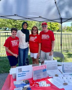 Moms Demand Action volunteers pose for a photo at a table stand