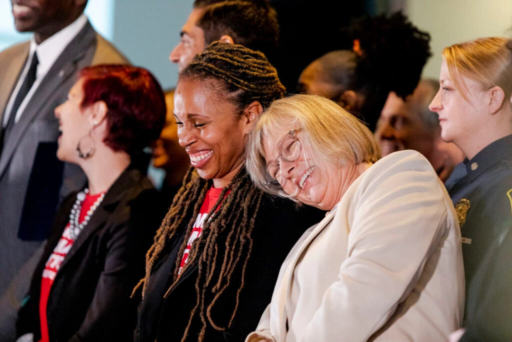 Angela Ferrell-Zabala smiling next to another Moms Demand Action volunteer
