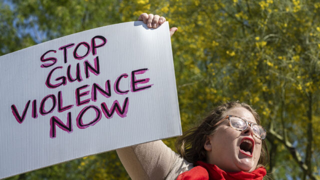 A person holds up a Stop Gun Violence Now sign