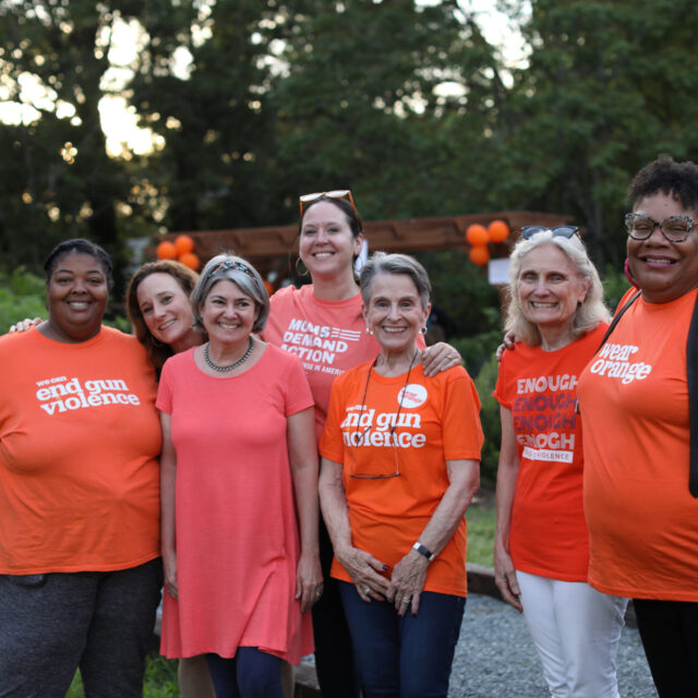 Moms Demand Action volunteers pose for a photo wearing Wear Orange t-shirts