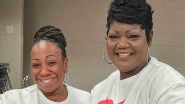 Two Black women wear white shirts that read